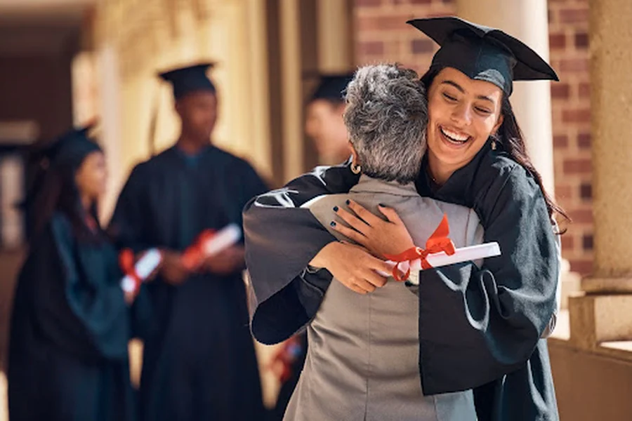A mother hugs her graduating daughter.